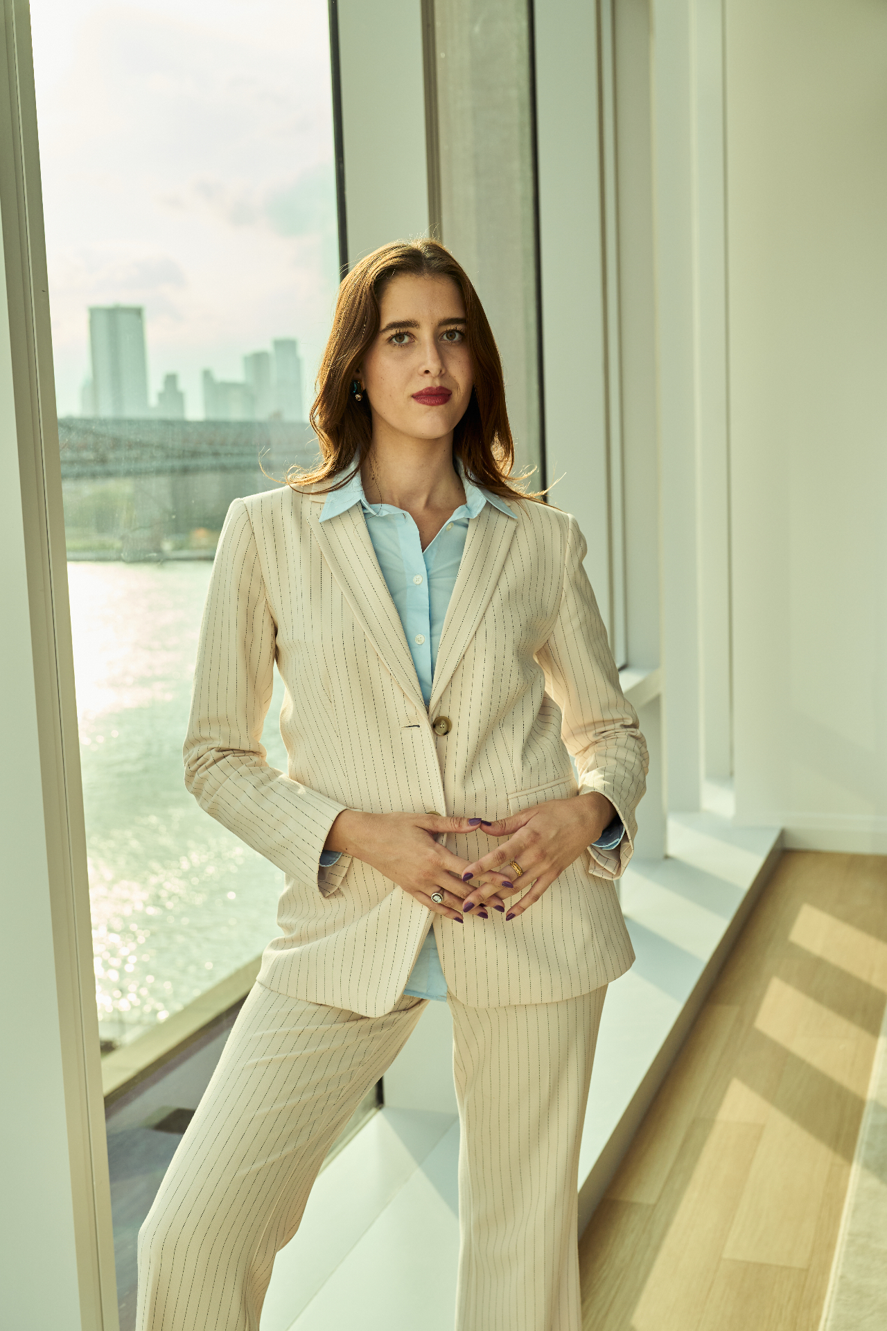 Valerie Chapman in a cream suit beside a window